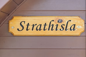 A wooden sign with the name 'Strathisla' mounted on a wall.