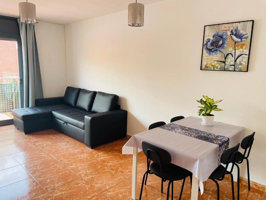 Una sala moderna con un sofá modular, una mesa de comedor con sillas y una planta en maceta.