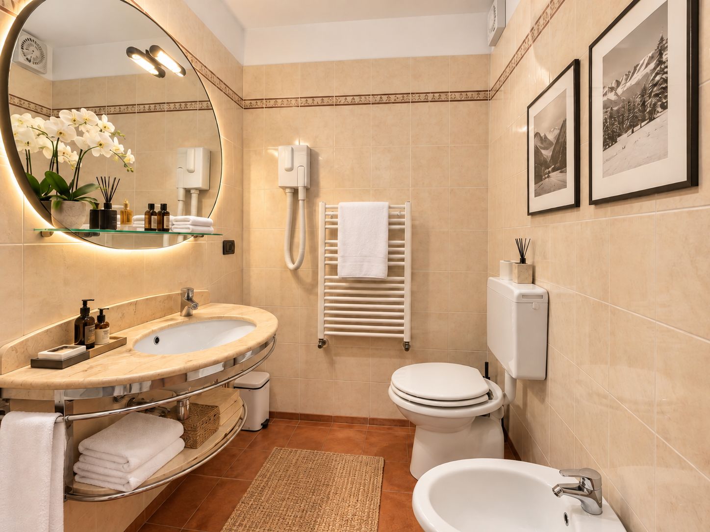 A modern bathroom with a sink, toilet, and bidet, a towel rack, and a mirror with a plant.