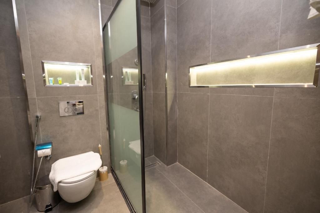 Une salle de bain moderne avec une douche à parois de verre, des toilettes et un meuble-lavabo avec un miroir.