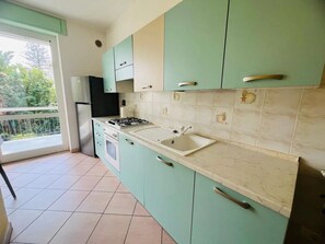 A kitchen with teal cabinets, a gas stove, and a sink. - New Listing (Sanremo)