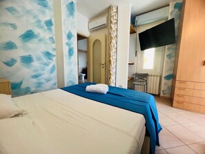A bedroom with a bed, a desk, and a wardrobe. - New Listing (Sanremo)