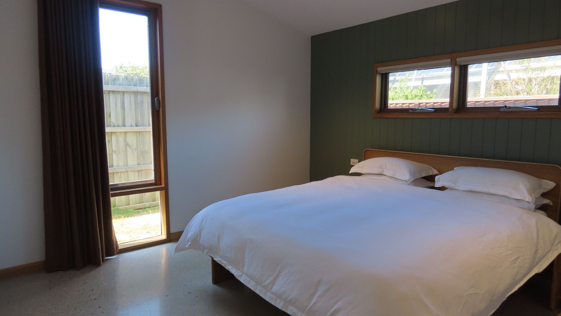 Un dormitorio con cama, ventana y vistas al exterior.