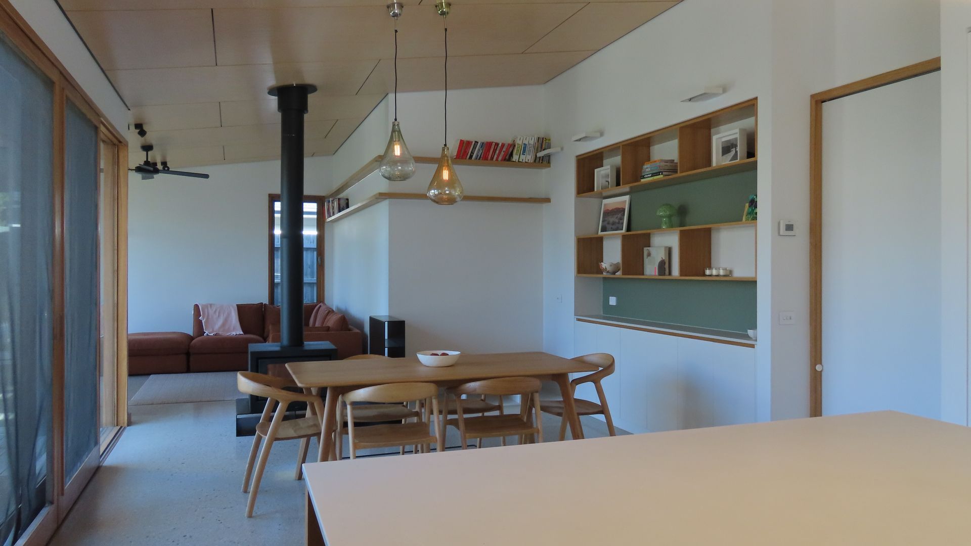 Une pièce comprenant une table à manger, des chaises, un canapé, une bibliothèque et une cheminée.