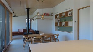 Une pièce comprenant une table à manger, des chaises, un canapé, une bibliothèque et une cheminée.
