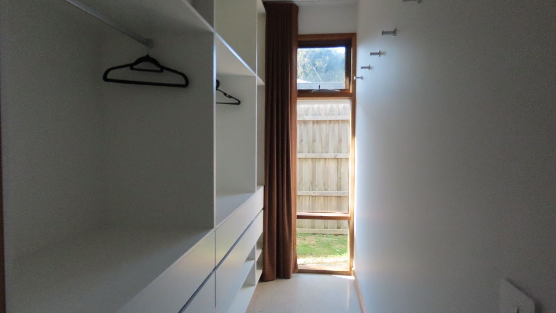 Un pasillo estrecho con una puerta de madera que da a un balcón.