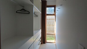 Un pasillo estrecho con una puerta de madera que da a un balcón.