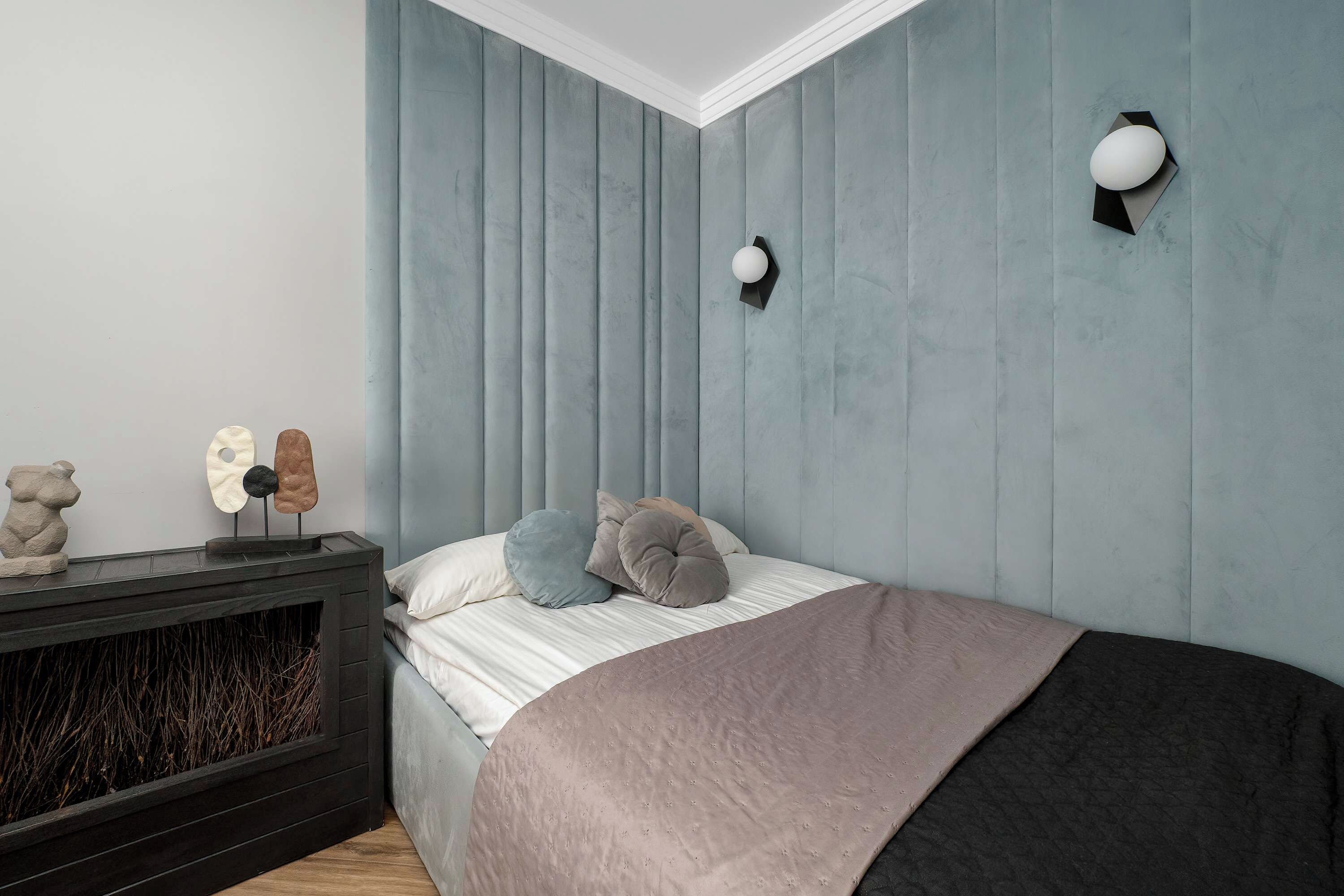 Un dormitorio con una cama, una chimenea y un aplique de pared.