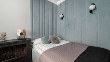 Un dormitorio con una cama, una chimenea y un aplique de pared.