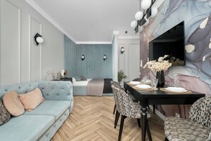 Un salon moderne avec un canapé, une table à manger et des chaises.