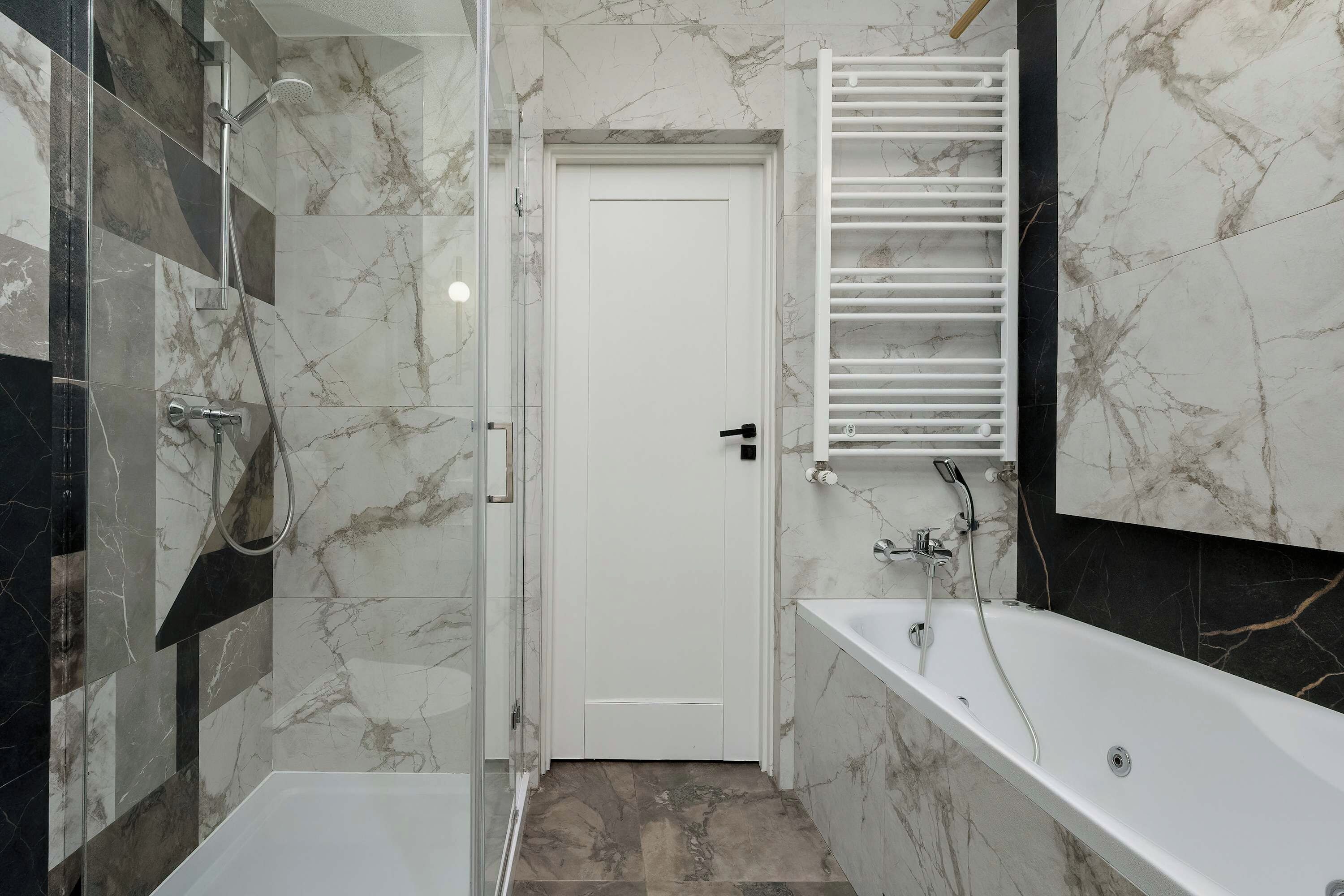 Een moderne badkamer met een douche, een bad en een toilet.