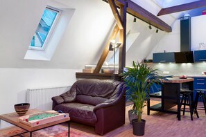 Ein Loft mit Essbereich, einer Ledersofa, einem Tischtennisch und einer Topfpflanze.