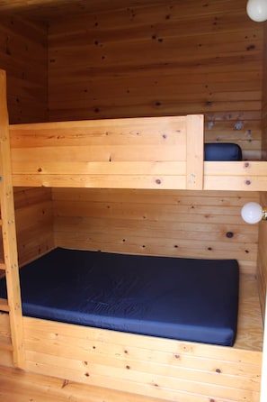 Ein Stockbett mit einer unteren Schlafgelegenheit und einer Matratze.