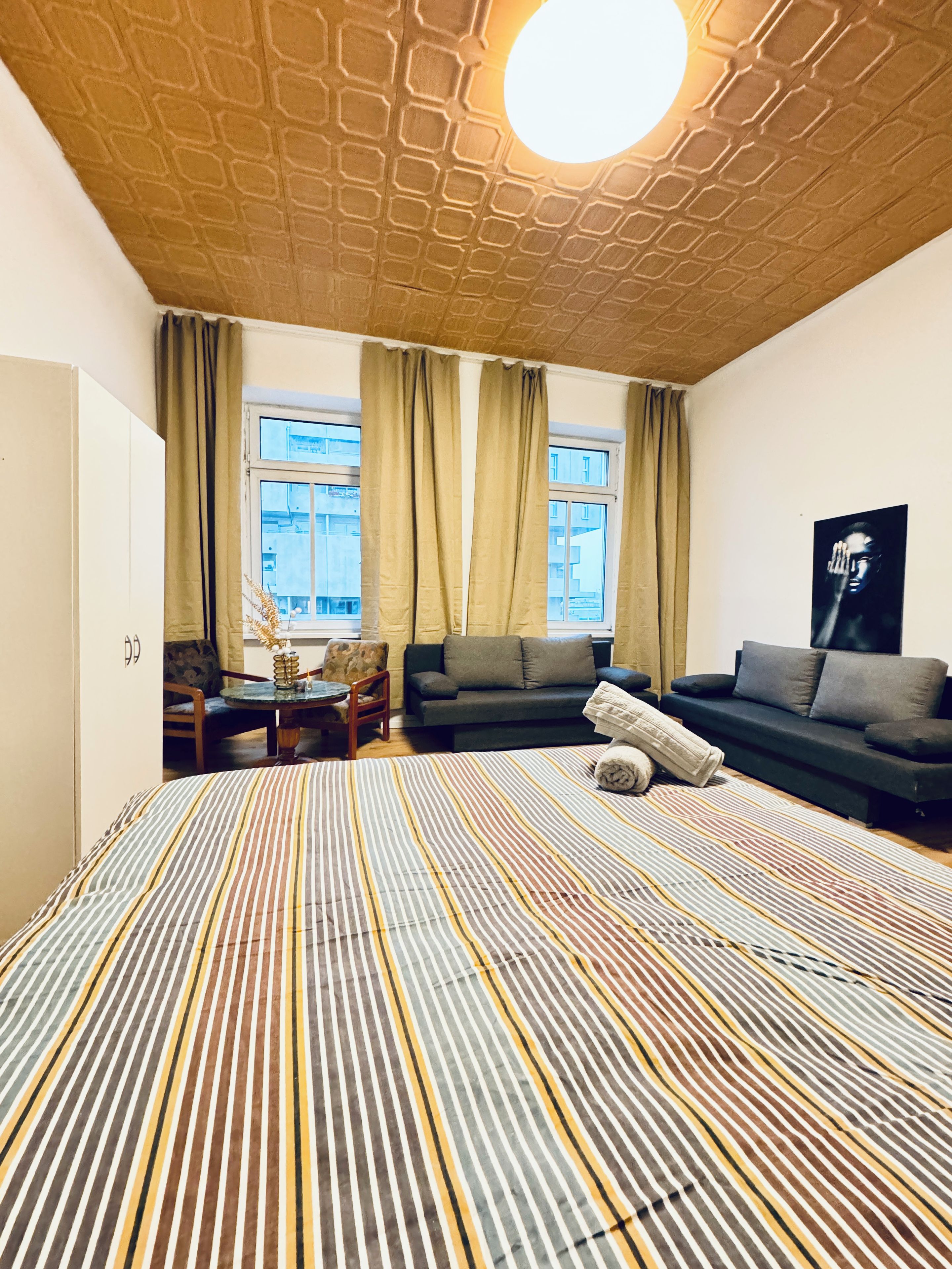 Een moderne kamer met een kamerbreed tapijt, een bank, een stoel, een kleine tafel en een raam met gordijnen.