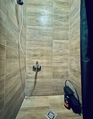 A shower with a handheld showerhead, a wall-mounted faucet, and a shower caddy. - The Vienna Quartet Studio for Four (Wien)