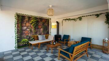 A cozy indoor seating area with a stone wall mural, a fireplace, and a checkered floor.