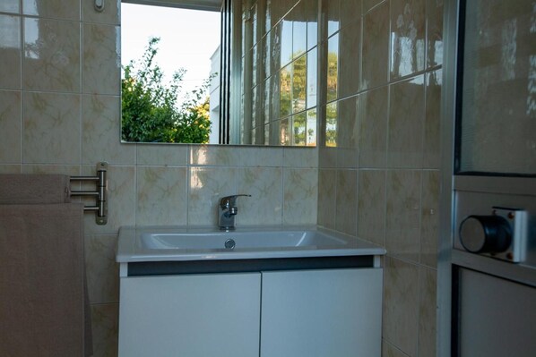A bathroom with a sink, mirror, and window. - Aroeira Garden Villa (Aroeira)