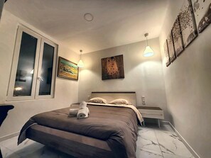A bedroom with a bed, bedside tables, a window, and wall art. - Bed and Breakfast 'Ignis - Chambre 4' with Mountain View, Wi-Fi and Air Conditioning (Berre-les-Alpes)