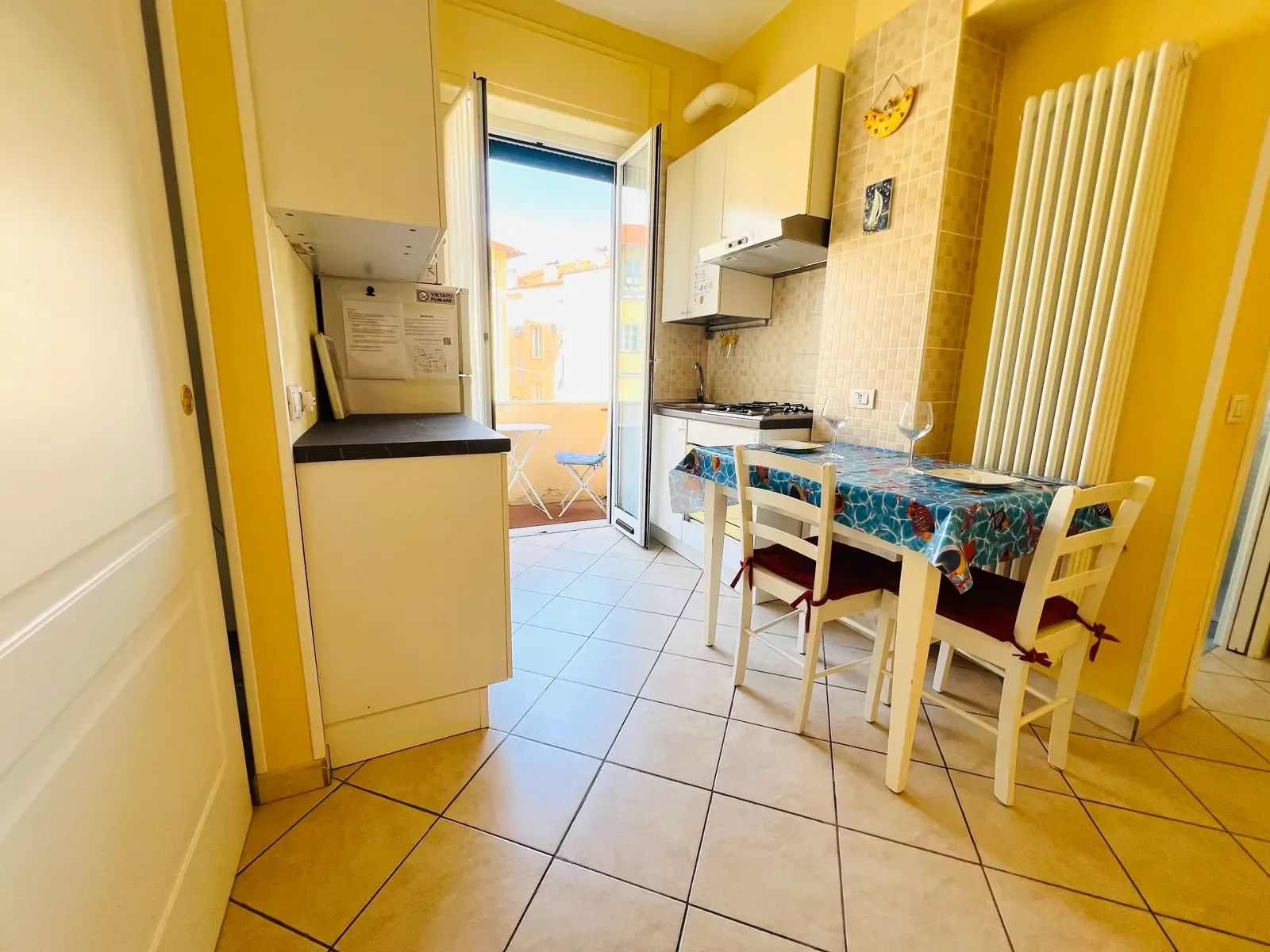 A kitchen with a dining table, chairs, and a view of the outside.