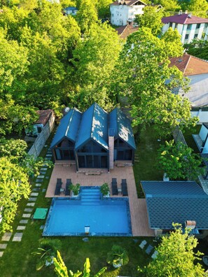 Una propiedad residencial con una terraza grande, piscina y un jardín bien cuidado.