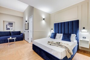 A modern hotel room with a large bed, a sofa, and a small table. - Muzio Private Suites by Premium Suites Collection (ROME)