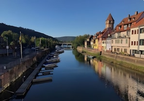 A calm river with boats docked on the left, flanked by colorful buildings with traditional architecture. - Apartment 'Wertheim-flair' with Wi-Fi (Wertheim)