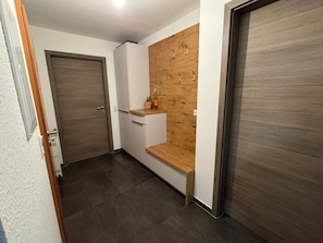A hallway with a wooden bench, a door, and a small cabinet. - Apartment 'Wertheim-flair' with Wi-Fi (Wertheim)