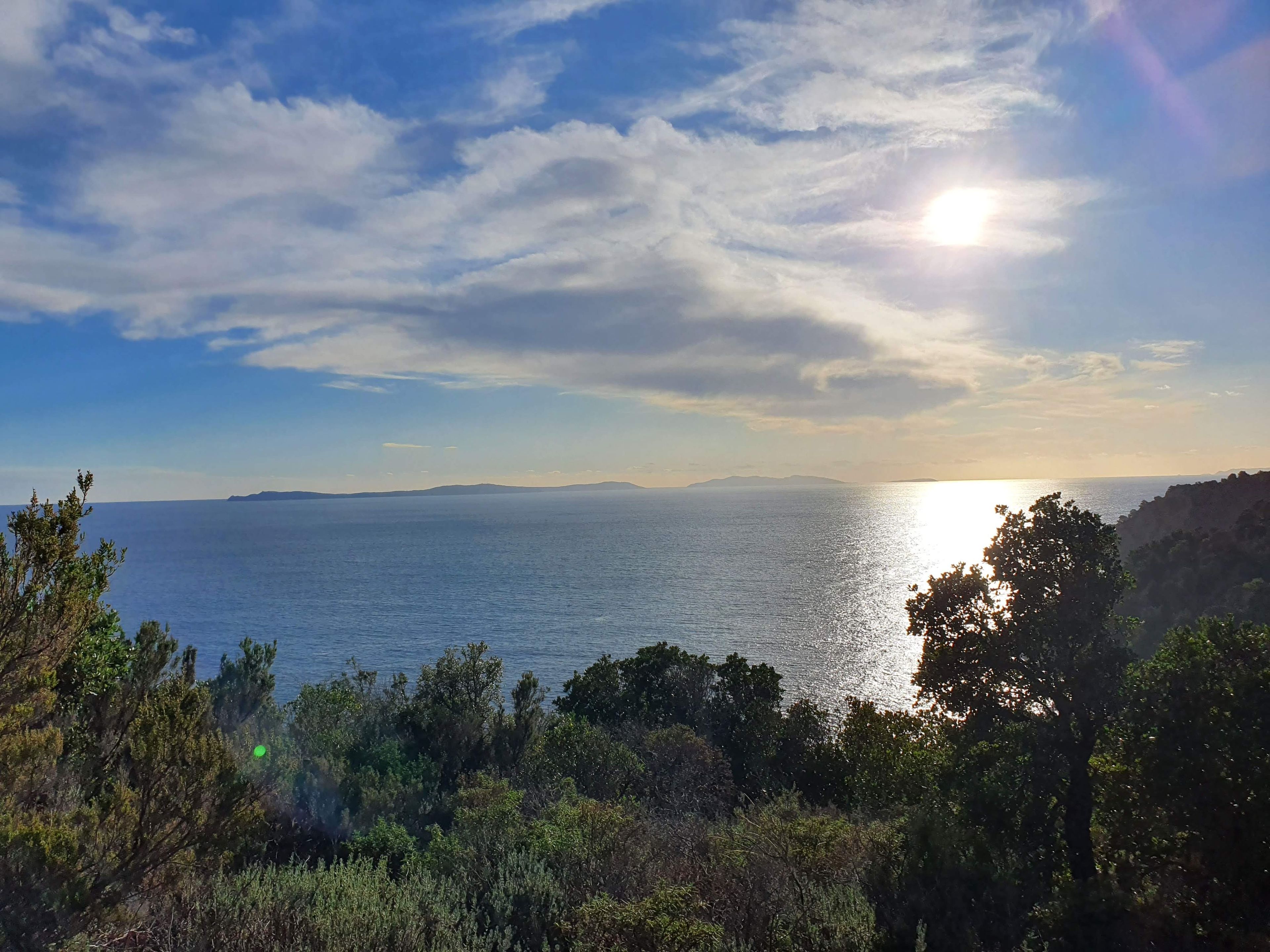 Un paisaje costero con vista al mar y a formaciones terrestres distantes.
