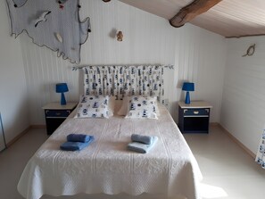 Quarto com uma cama, duas mesas de cabeceira e mosquiteiro.