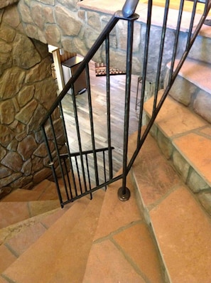 A staircase with a stone wall on one side and a metal railing. - Aspen Song Mountain Retreat (Jefferson County)