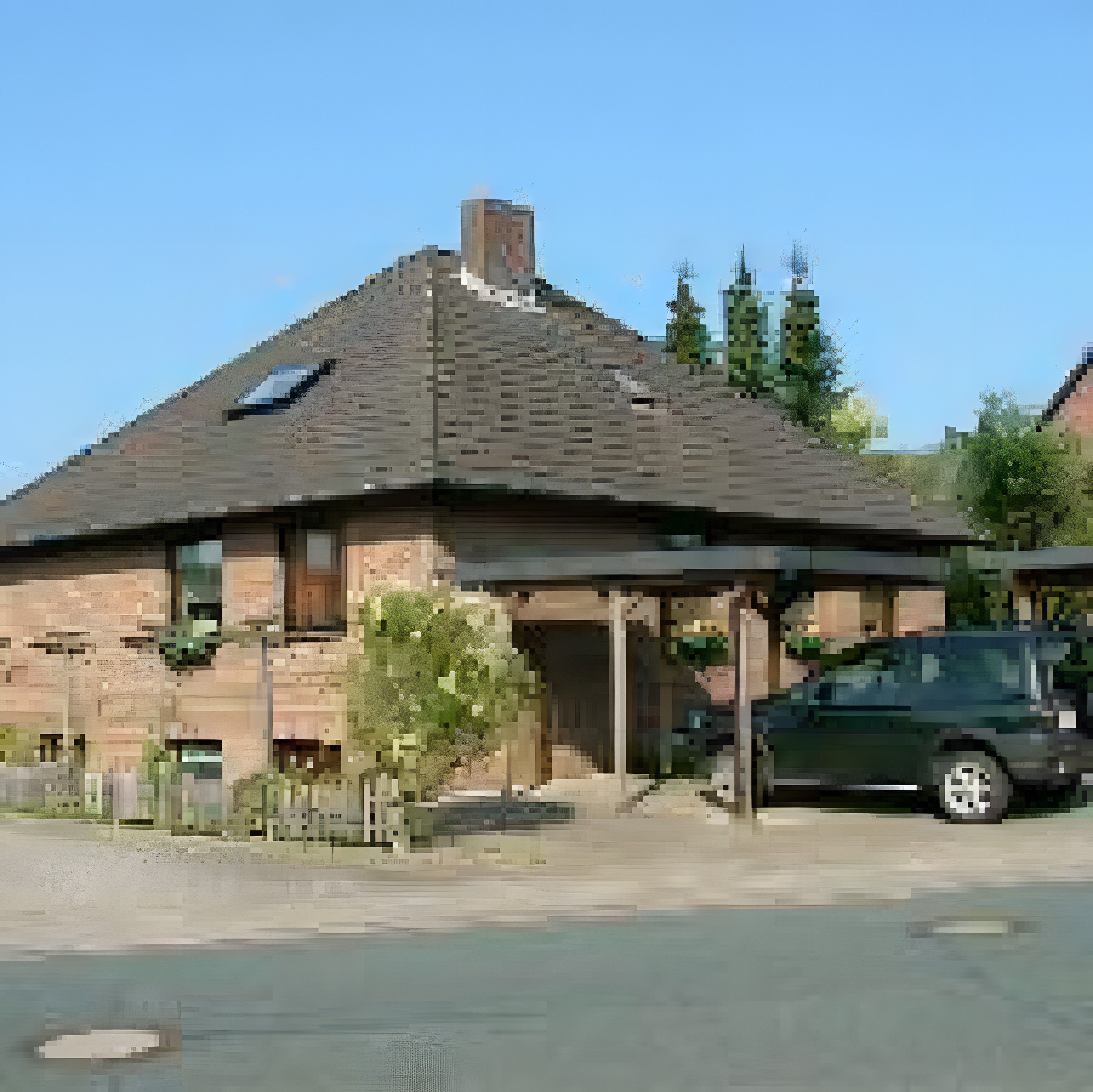 Een tweelaags huis met een overdekte veranda en een auto ervoor geparkeerd.