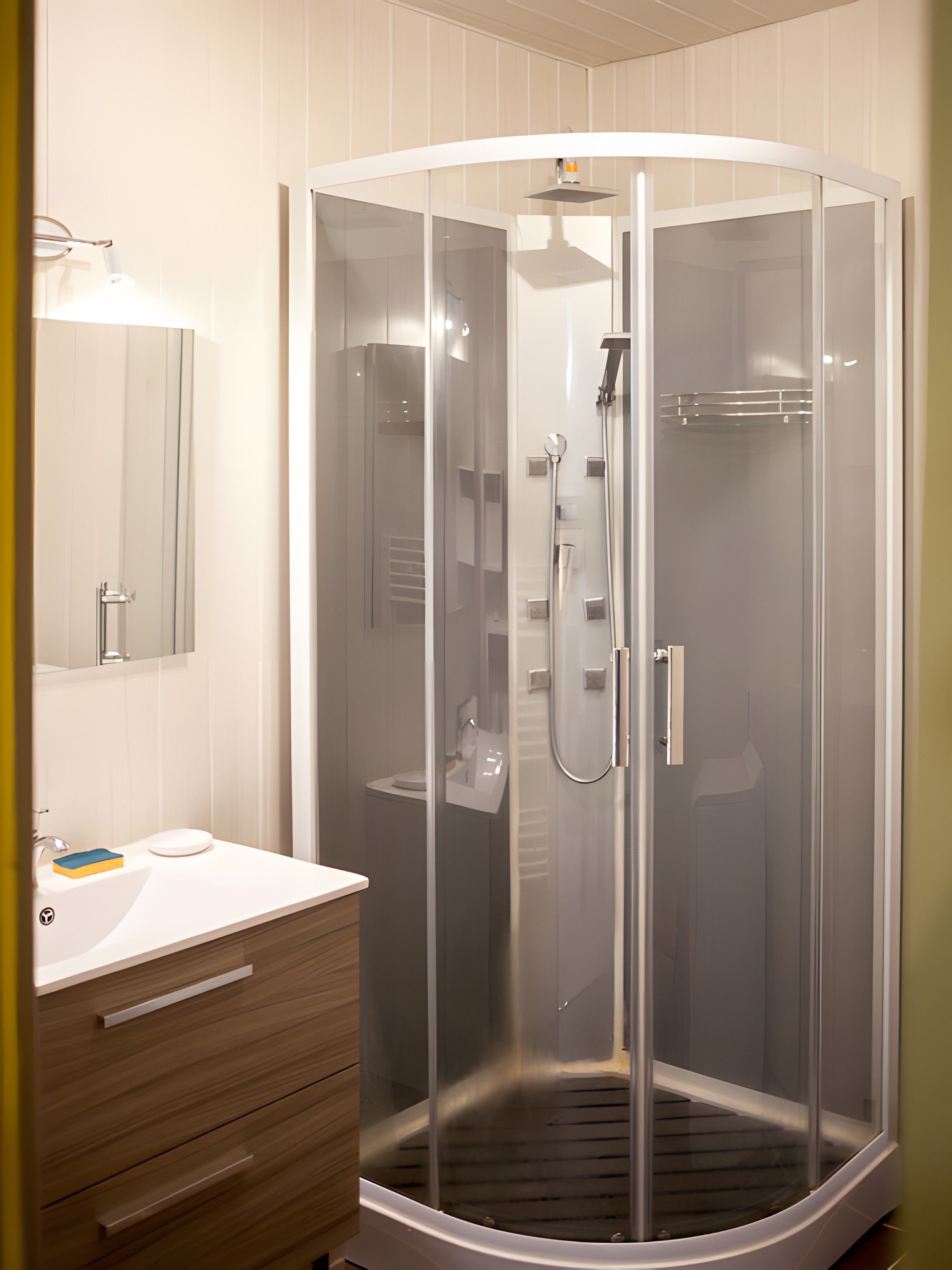 A modern bathroom with a glass-enclosed shower, a white sink, and a wooden vanity.