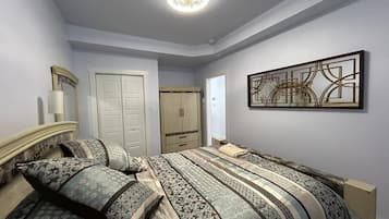Un dormitorio con una cama, un armario, un espejo y una obra de arte en la pared.