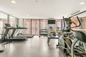 Een sportschool met loopbanden, elliptische trainers en losse gewichten.
