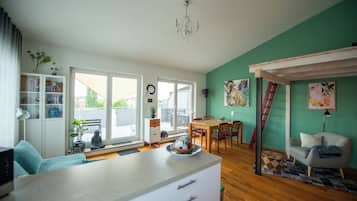 Un espacio de estar moderno con comedor, cocina y vistas amplias a través de grandes ventanales.