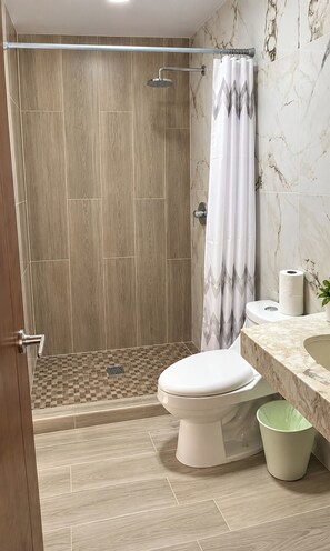 Un baño moderno con ducha, inodoro y lavabo.