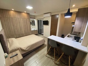 Ein modernes Schlafzimmer mit einem Bett, einem Nachttisch und einem kleinen Schreibtisch mit Stuhl.