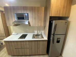 A compact kitchen with a microwave, a refrigerator, and a sink. - Stay in a Great Location with a Queen-Size Bed | SB203 (San Nicolás de los Garza)