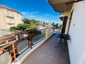 En balkon med udsigt over et boligområde, et bord og en stol.
