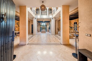 A spacious lobby with a high ceiling, a central staircase, and a decorative chandelier. - New Listing (Marrakech)