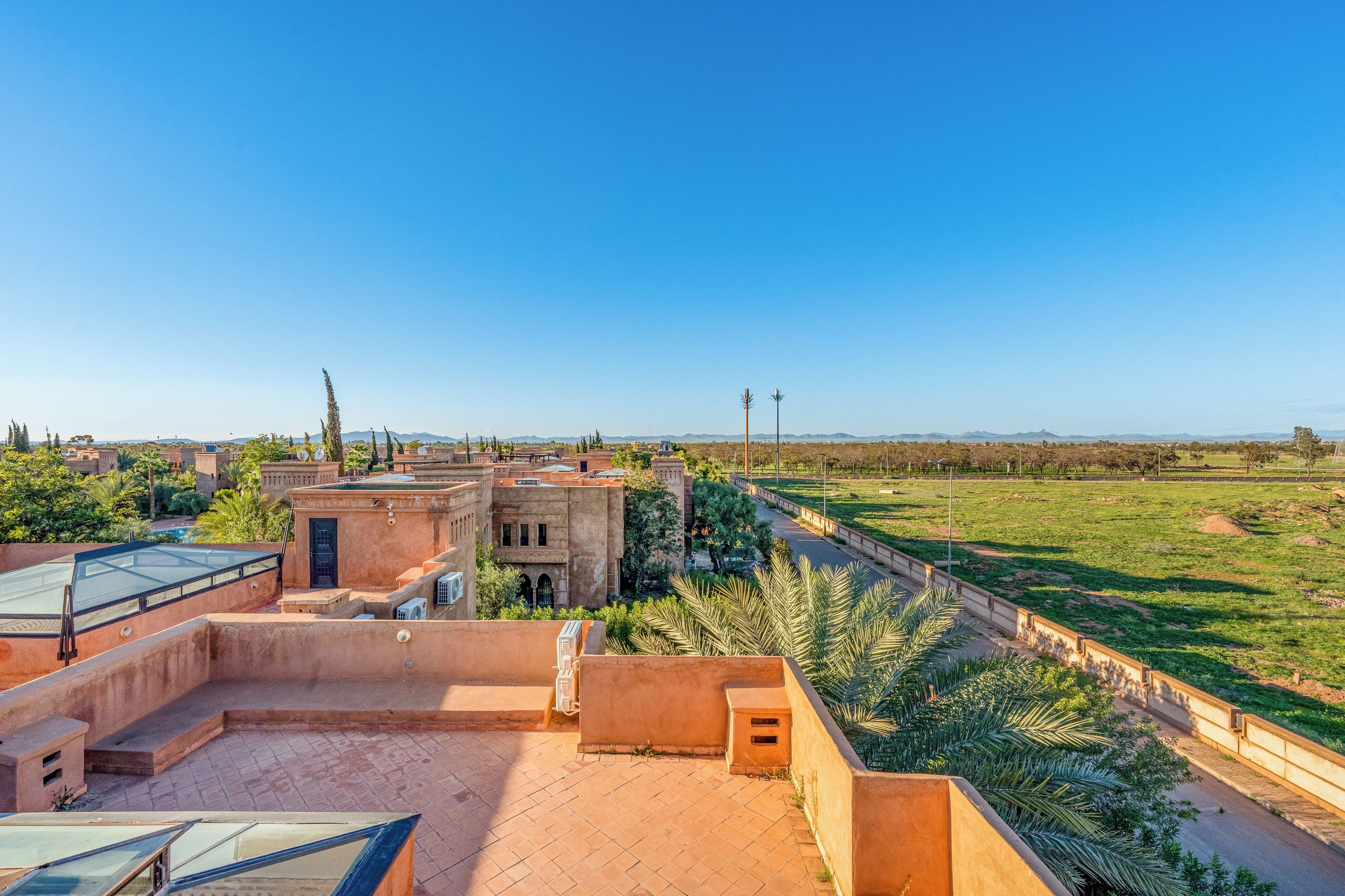 A rooftop terrace with a view of a cityscape and distant mountains.