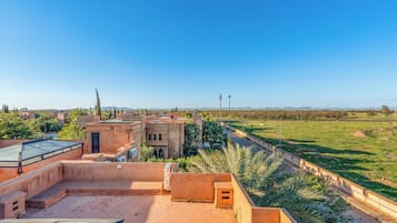 A rooftop terrace with a view of a cityscape and distant mountains.