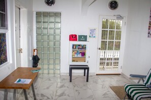 A room with a wooden table, a bench, a first aid kit, and a door with a window. - Thebreeze2022 (St Toolies,  Tollgate, Clarendon Park)