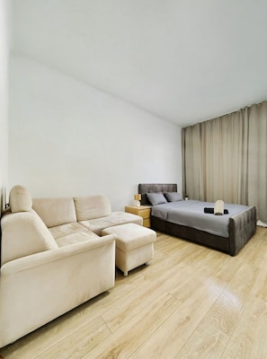 Een moderne slaapkamer met een slaapbank, een bed en een nachtkastje.