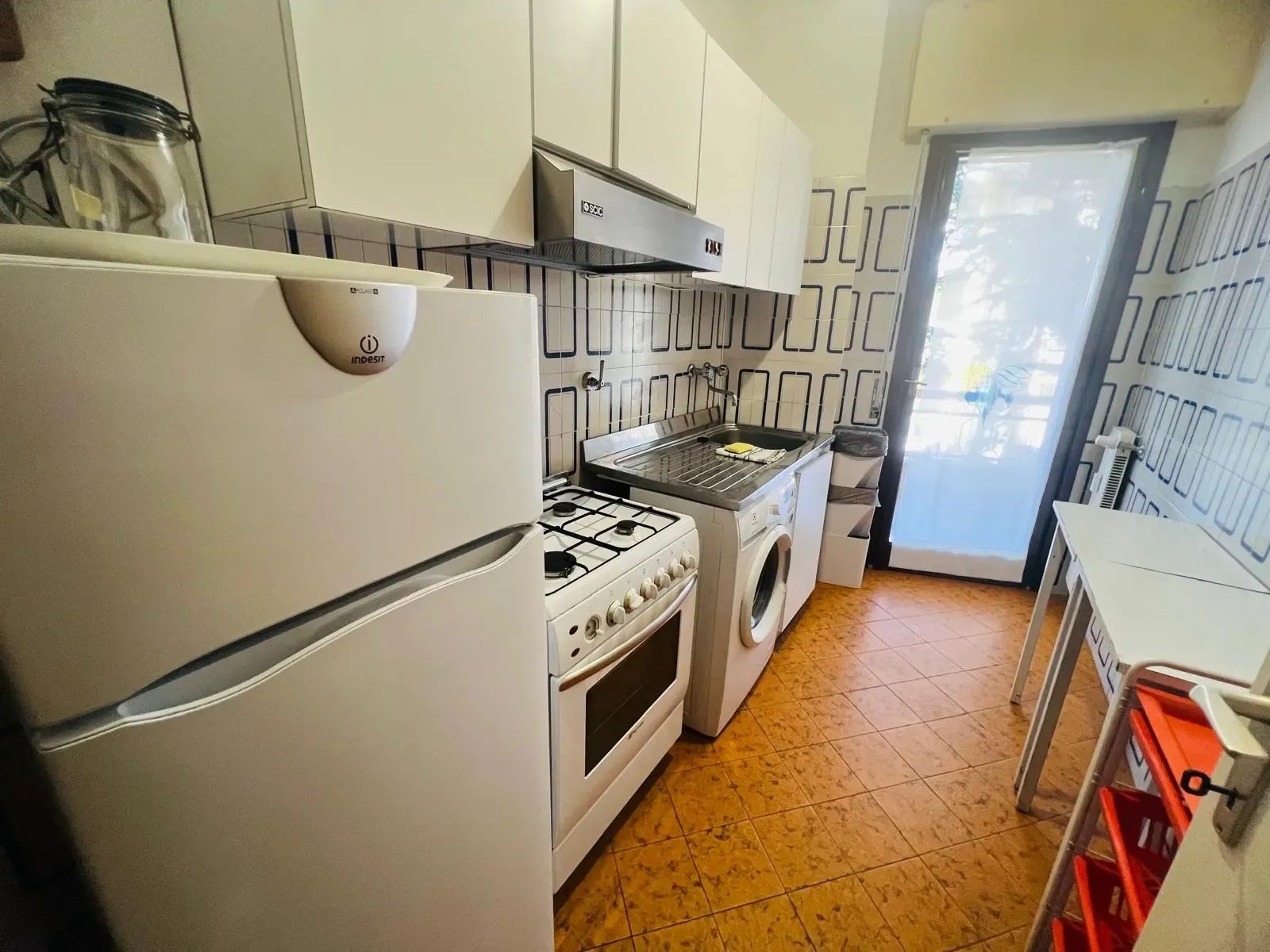 A compact kitchen with a gas stove, oven, and a built-in washing machine.