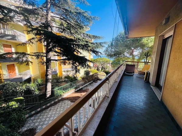 A balcony with a view of a building, a tree, and a chair. - New Listing (Sanremo)