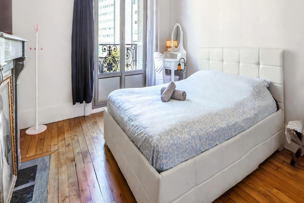 Un dormitorio con una cama grande, un aparador, un tocador con espejo y una ventana con cortinas.