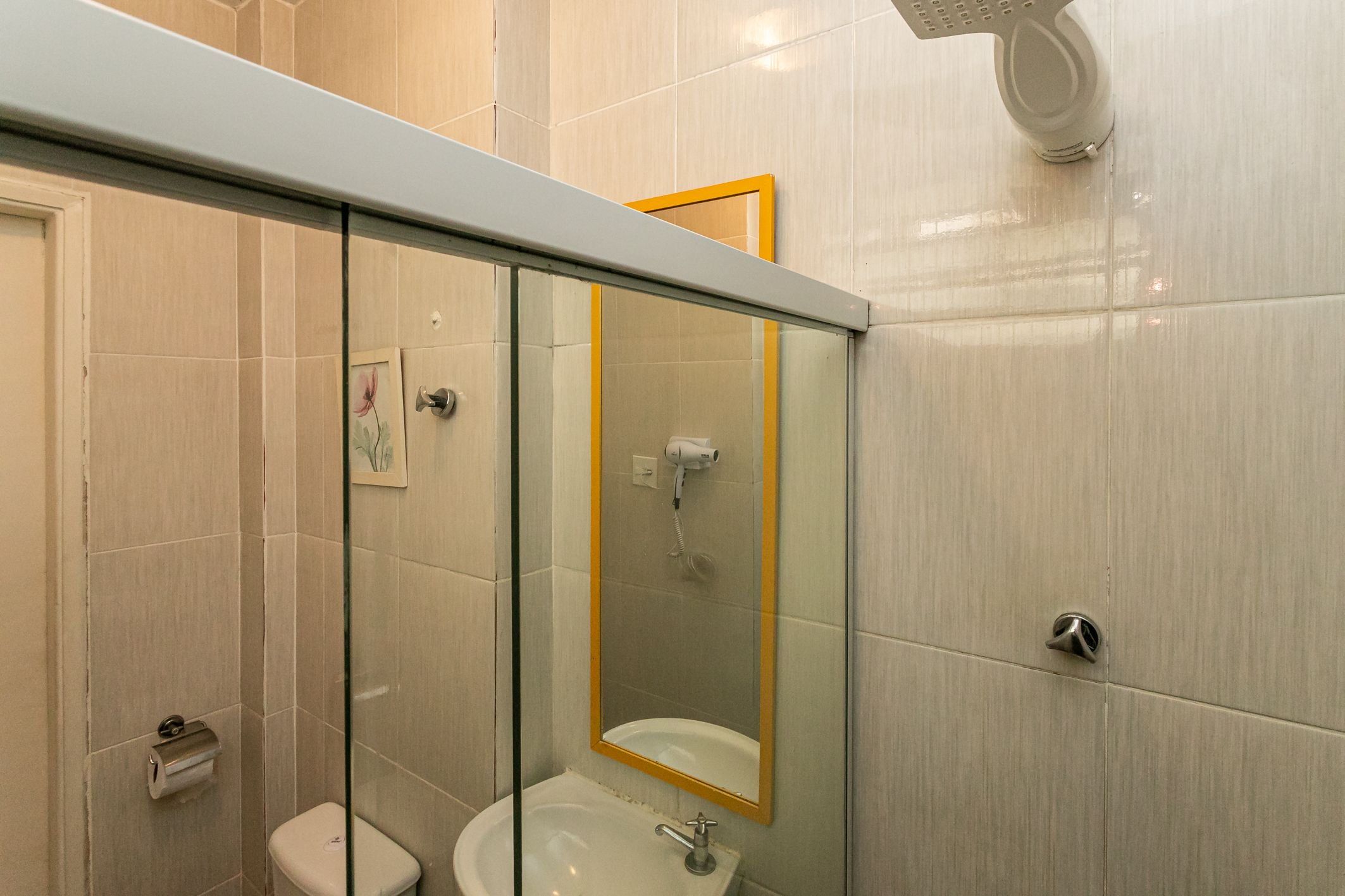 Ein modernes Badezimmer mit Duschkabine aus Glas, Toilette und Waschbecken mit Spiegel.
