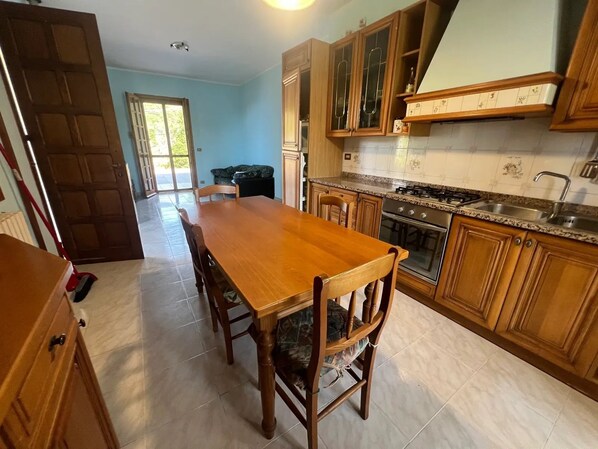 Una cocina con armarios de madera, encimera de granito y una mesa de comedor con sillas.