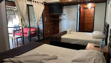 A hotel room with two beds, a large window with curtains, a TV, and a wooden ceiling.